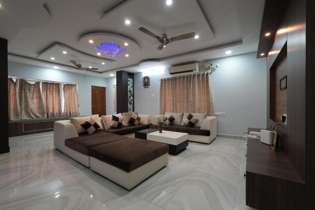 蒂鲁帕蒂Paradise villas - duplex 5bhk - A Golden Group Of Premium Home Stays - tirupati的客厅配有沙发和桌子