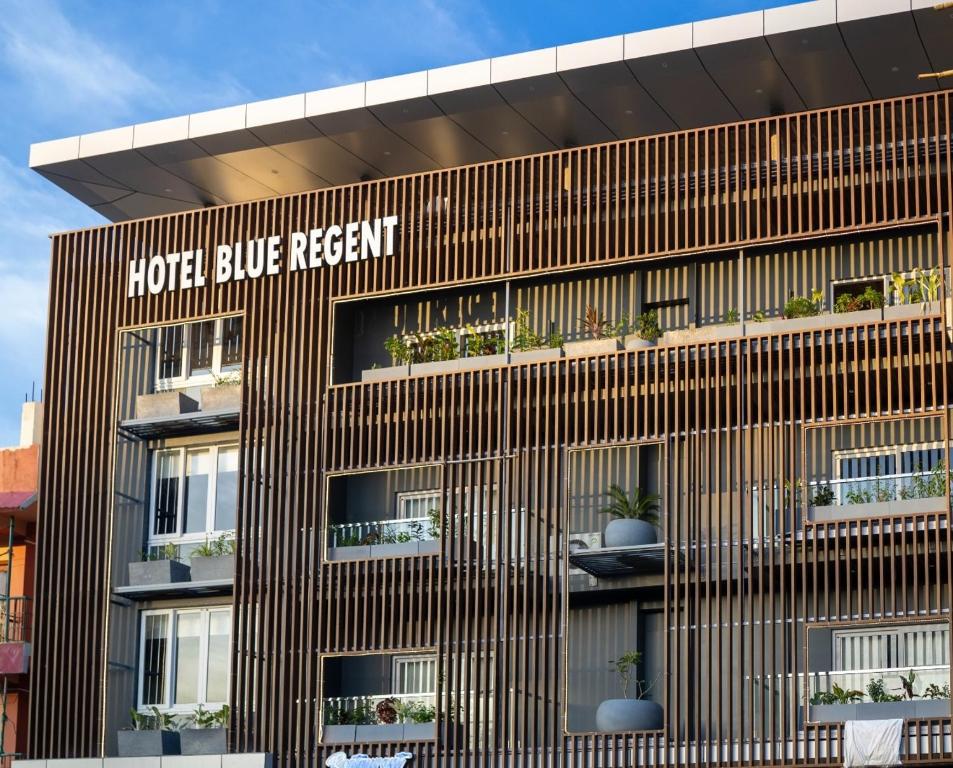 布莱尔港HOTEL BLUE REGENT的棕色的建筑,上面有盆栽植物