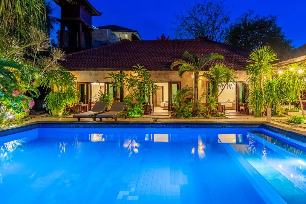 吉利阿尔Senang Luxury Villa的夜间带游泳池的别墅