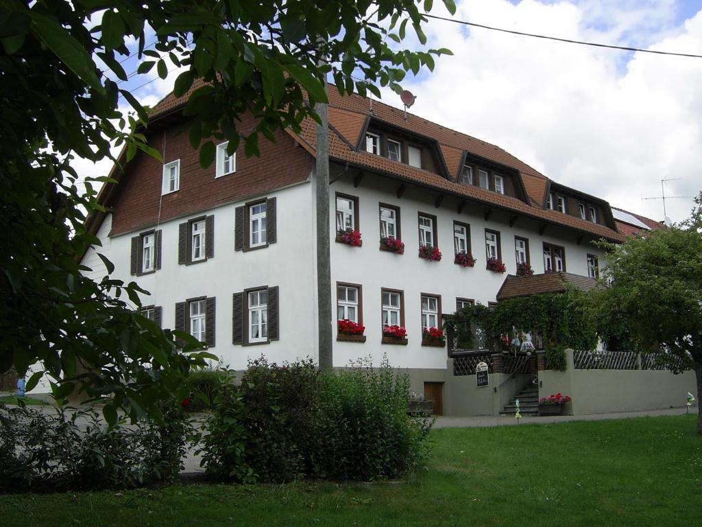 于林根-比肯多夫Gasthaus zum Schwanen的白色的大建筑,窗户上装有红色的鲜花