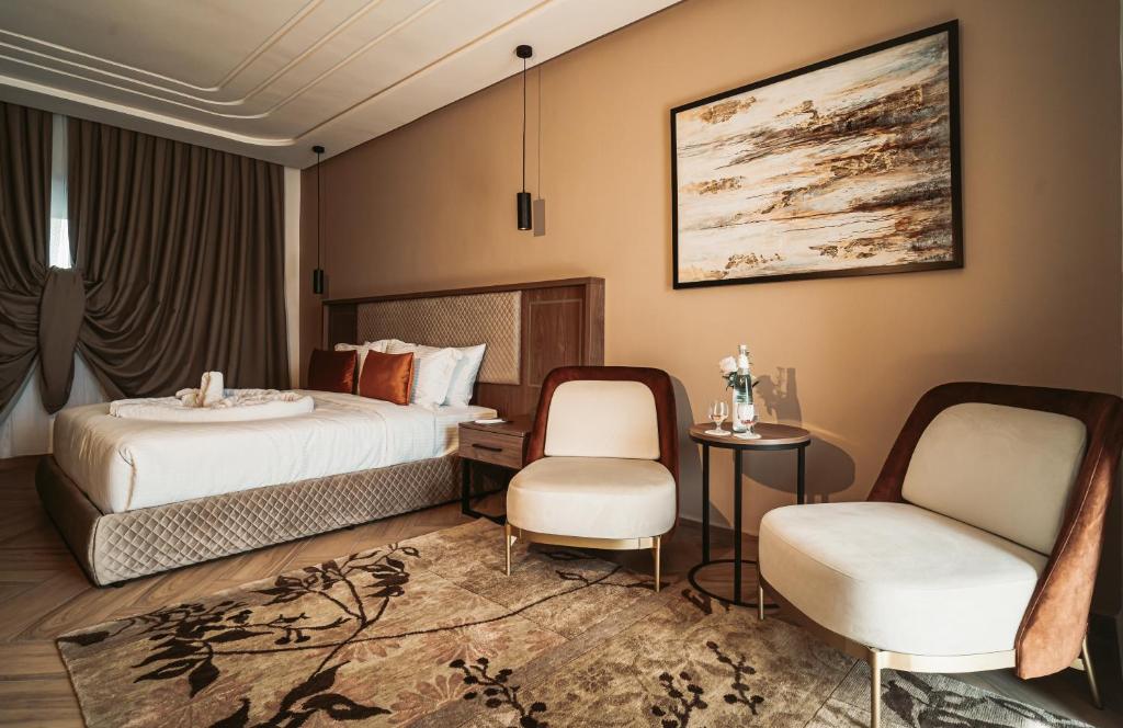 盖尼特拉City Hotel by Waves的酒店客房,配有一张床和两把椅子