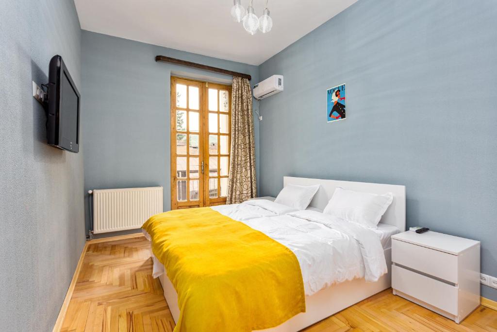 第比利斯Sunny Hotel Tbilisi的一间卧室配有一张黄色毯子床