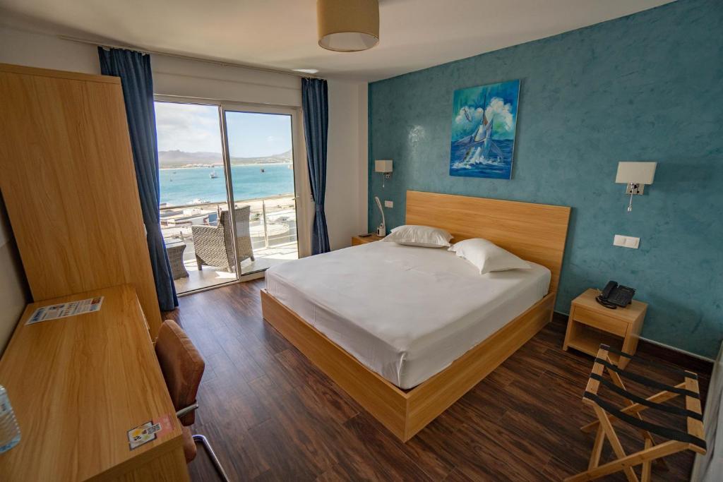 明德卢Blue Marlin Hotel的一间卧室配有一张床,享有海景