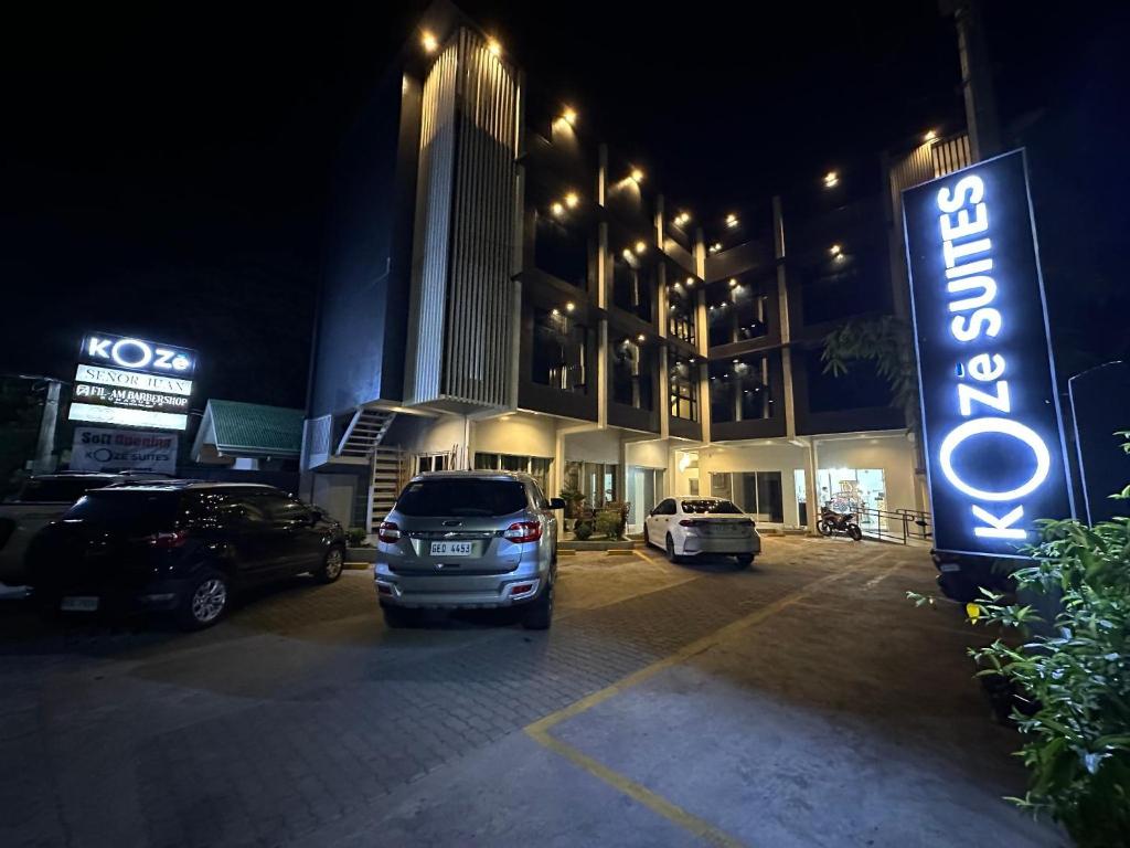 杜马格特Koze Suites的晚上在酒店前面的一个停车场