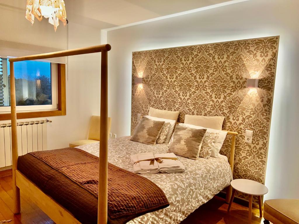 阿威罗Passadiços da Ria的一间卧室配有一张带四柱床的四柱床。