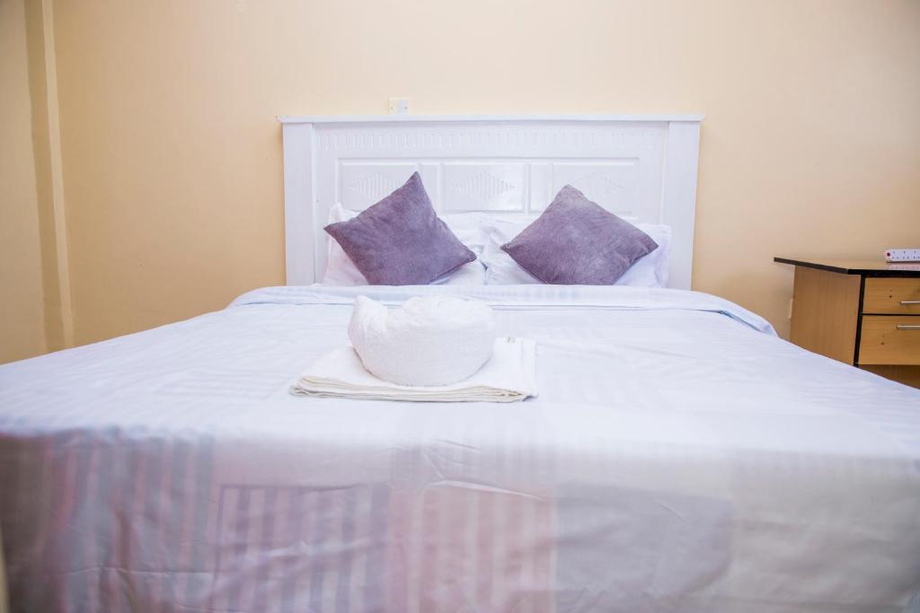 马查科斯Elnara Suites的白色床上的白色碗,带紫色枕头