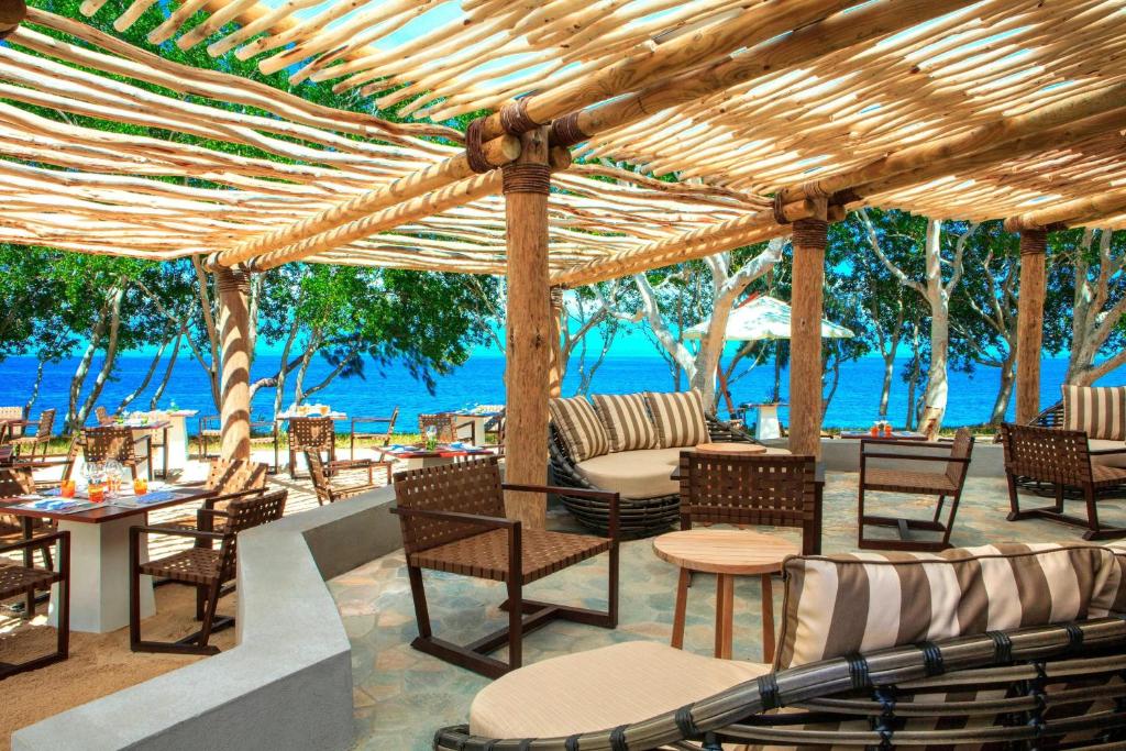 布拉伊新喀里多尼亚喜来登德瓦Spa及高尔夫度假酒店的一个带桌椅的庭院和大海
