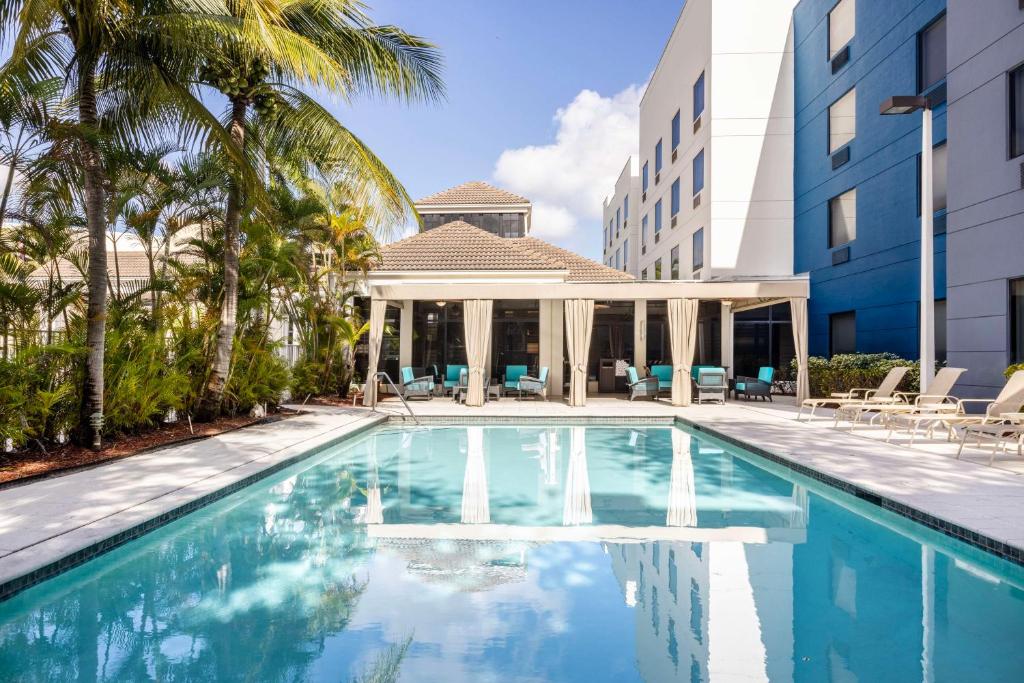 西棕榈滩西棕榈海滩机场希尔顿花园酒店的一座带凉亭的建筑前的游泳池