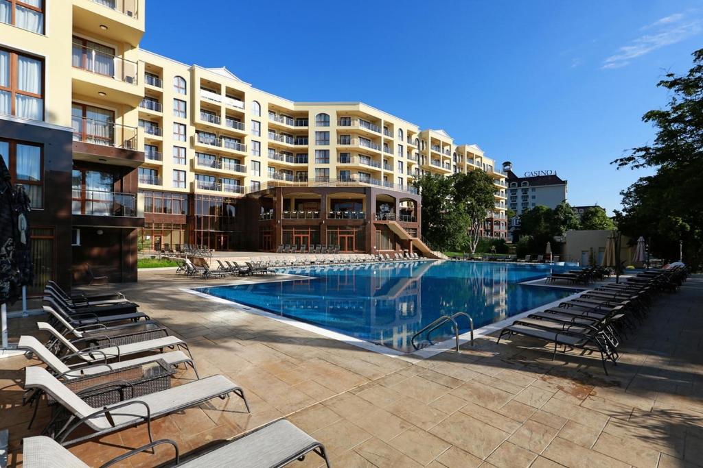 金沙黄金线公寓酒店的一个带椅子的大型游泳池和一间酒店