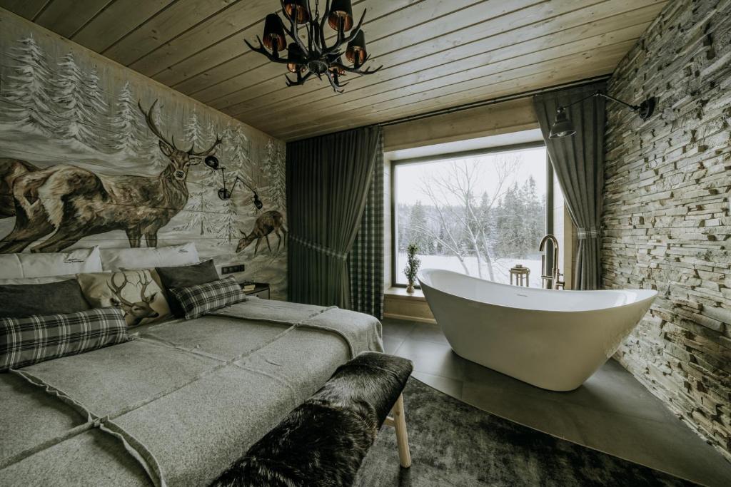 尤格Luxury Chalet Kajmer的带浴缸的浴室和带窗户的床