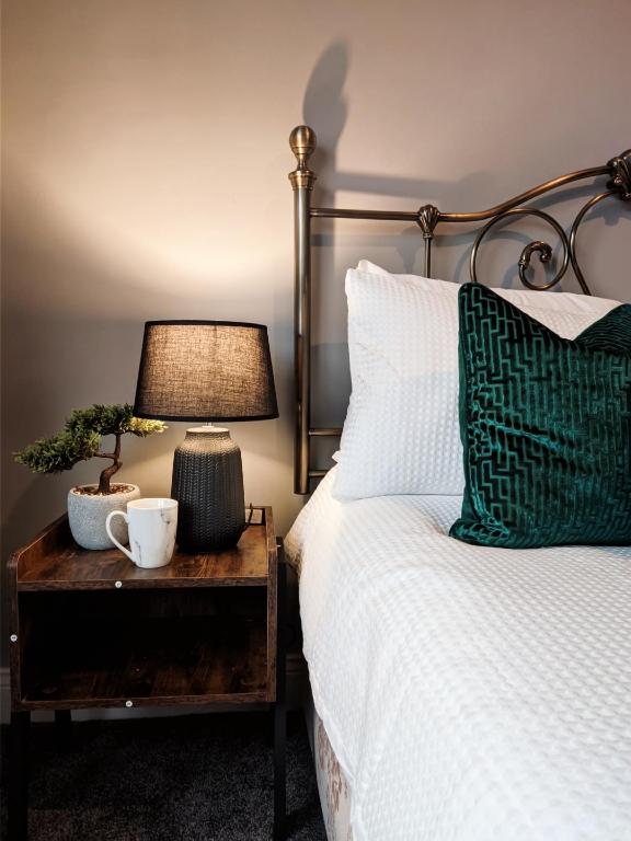 PallionA&A Luxury Stay Eldon Street的一间卧室配有一张带台灯的桌子的床