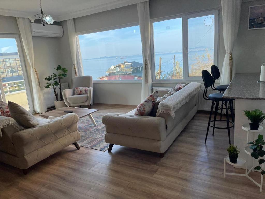 亚洛瓦Yalova Apartments的一间带两张沙发的客厅和一间享有船只景色的厨房