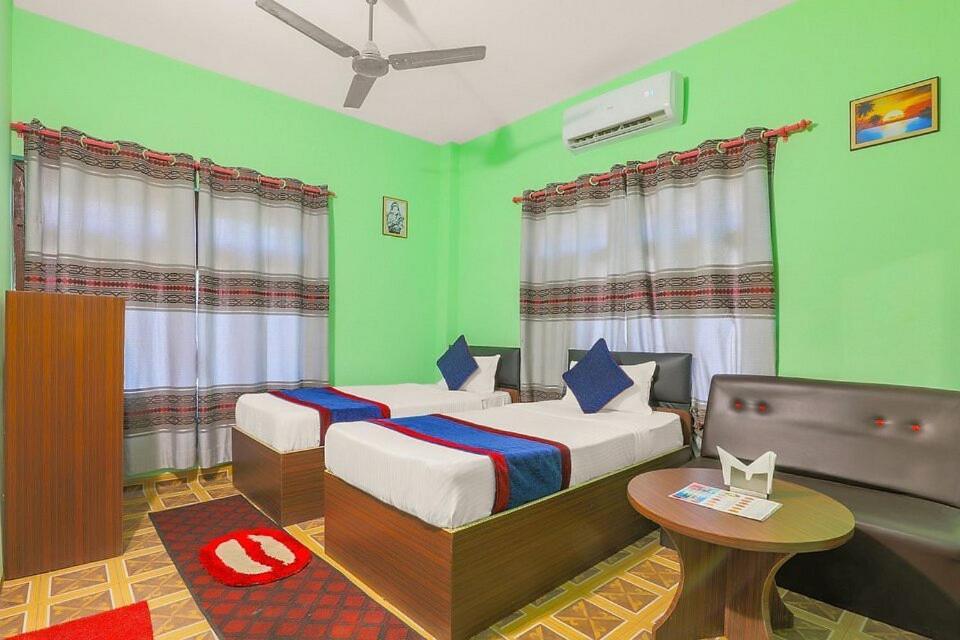 AtariaNamaste Hotel的一间设有两张床的卧室,位于带绿色墙壁的房间