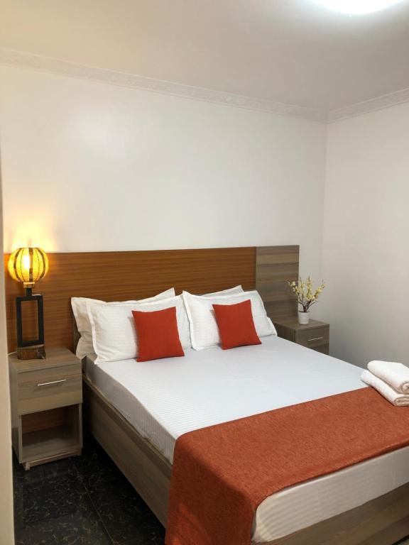 KakamegaSavwa Resort and Gardens的一间卧室配有一张带红色枕头的大床