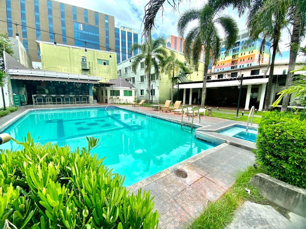 安吉利斯Hotel Euroasia By BLUEBOOKERS的一座种植了棕榈树和建筑的大型蓝色游泳池