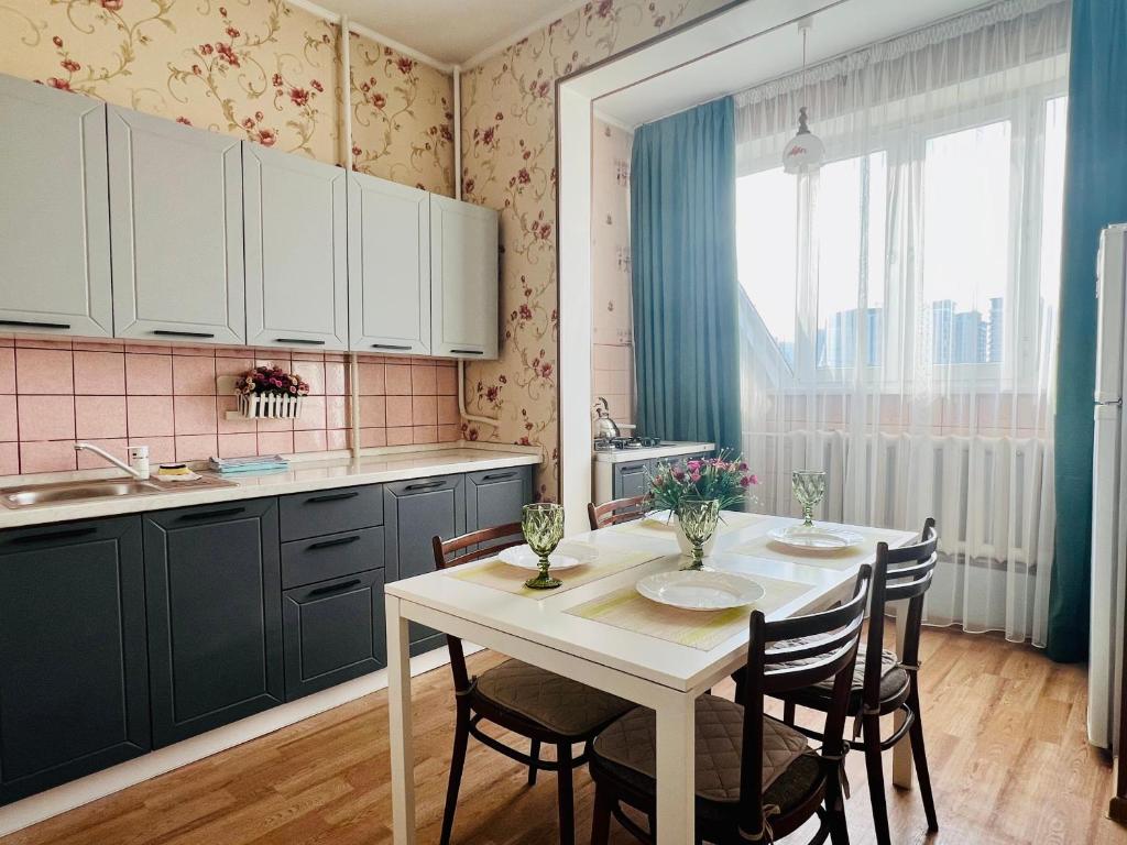 阿拉木图Cozy three-room apartment with Mountain view的厨房配有白色的桌椅和水槽