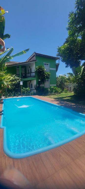 巴拉格兰德Pousada Cacau e Dendê的房子前面的蓝色游泳池