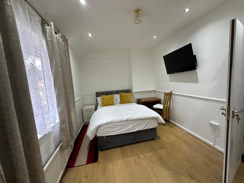 布罗姆利Double Room With Free WiFi Keedonwood Road的一间卧室配有一张床和一台平面电视