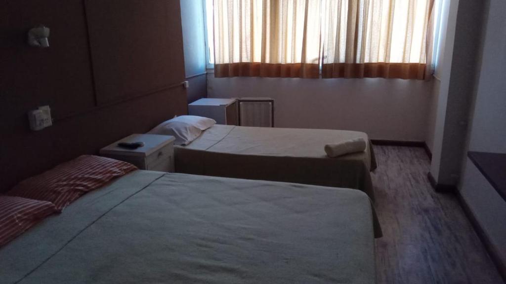 维拉卡洛斯帕兹HOTEL CRONOS的酒店客房设有两张床和窗户。