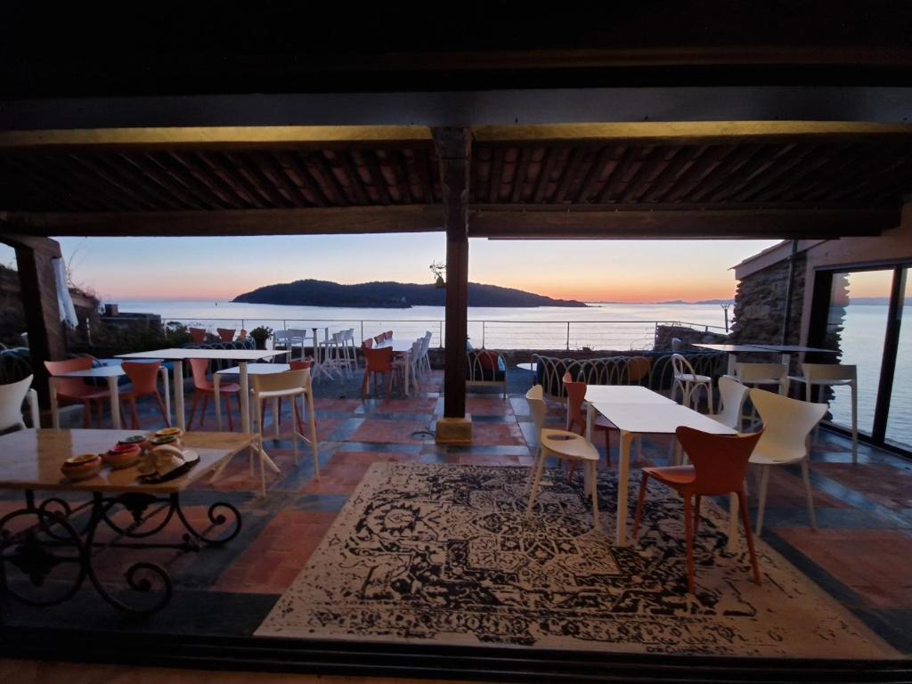 勒旺岛VILLA MANDRAGORE Ile du Levant的一间带桌椅的海景餐厅