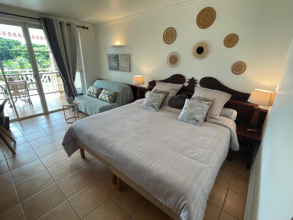 圣吕斯Studio Charme et cosy à Sainte-Luce Martinique的一间带大床的卧室和一间客厅