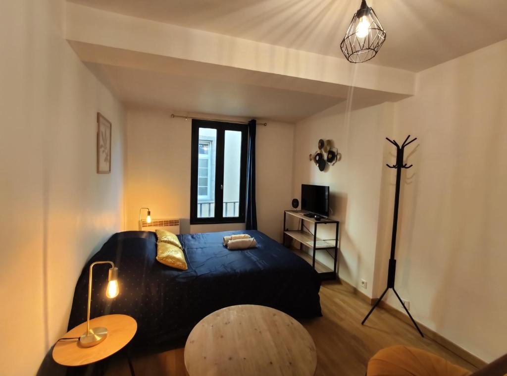 富瓦Le Charme - Focalimmo (Centre)的一间卧室配有一张黑色的床和一张桌子