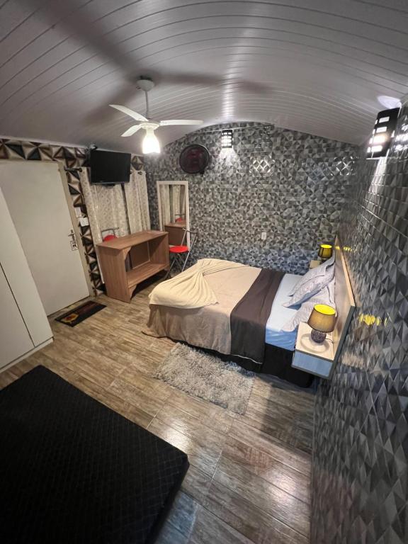 圣安东尼奥-杜皮尼亚尔Pousada Família的一间卧室设有一张床和石墙