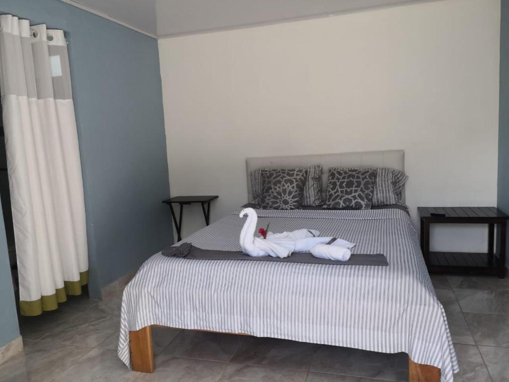 San JoséVilla el paraíso的一间卧室配有一张带两个天鹅的床