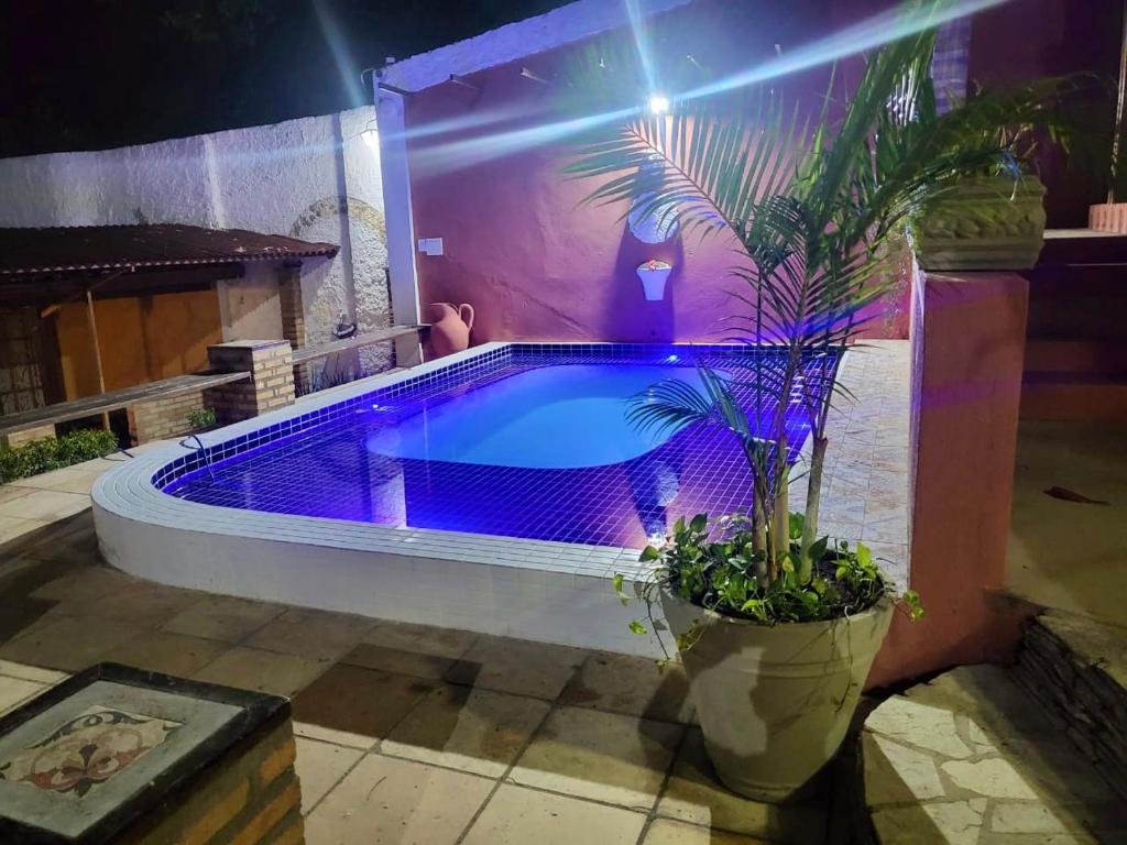 纳塔尔Pousada Saruê Natal Praia RN的紫色灯的房子里的一个游泳池