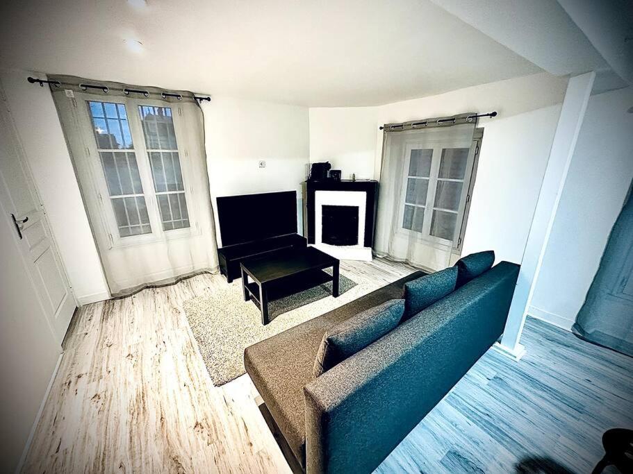 尚蒂伊Appartement duplex à Chantilly centre的客厅配有蓝色的沙发和桌子
