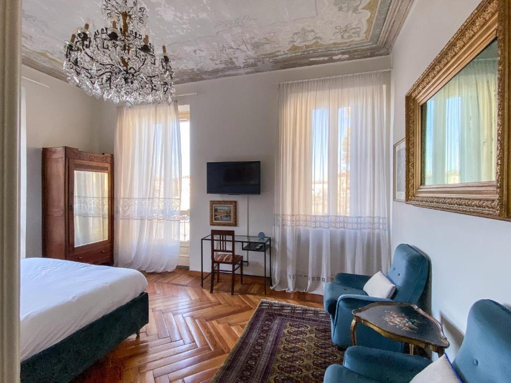 都灵L'Angolo di Casa Verrua的一间卧室配有一张床、椅子和吊灯