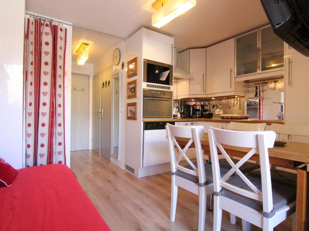 于埃Appartement Huez, 2 pièces, 5 personnes - FR-1-405-341的厨房配有白色橱柜和桌椅