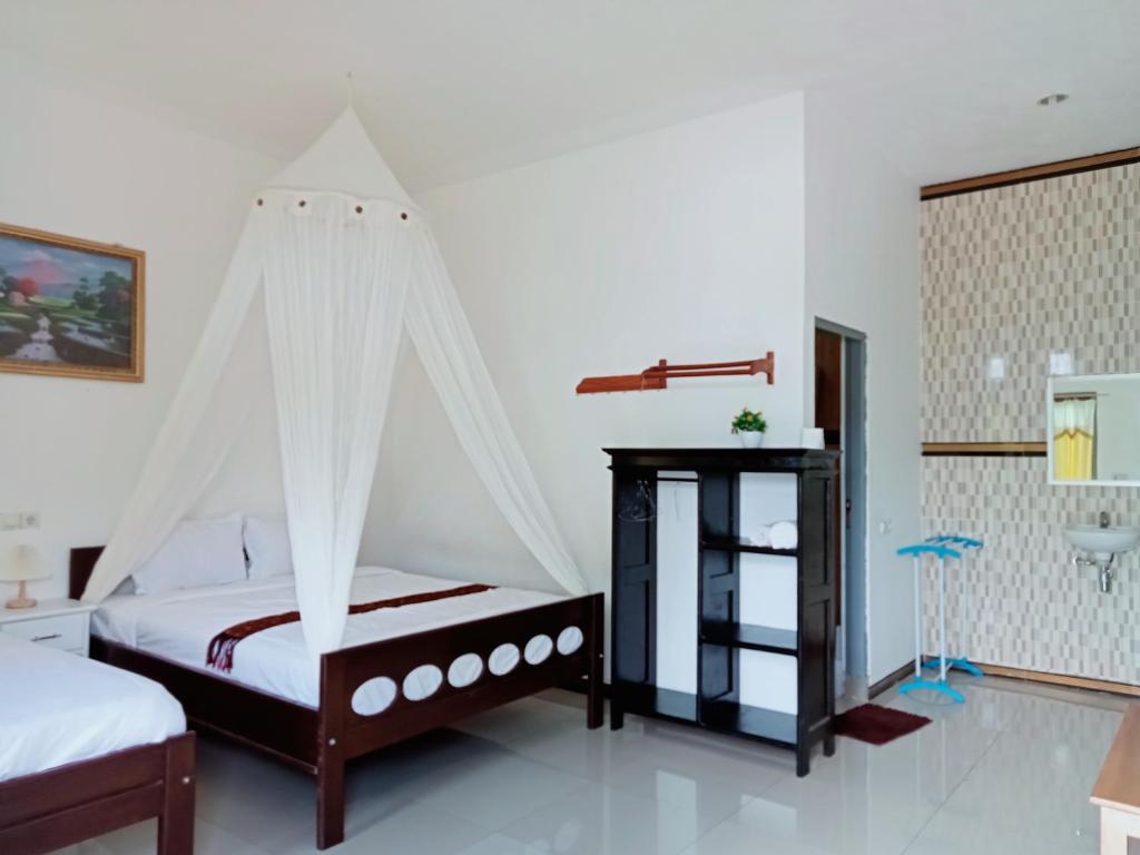 克里穆图Mahakali的一间卧室配有一张带蚊帐的床