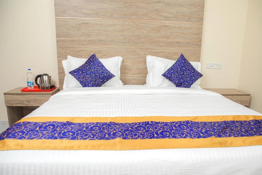 钦奈RedFox Hotel-T.Nagar的一间卧室配有一张带蓝白色枕头的大床