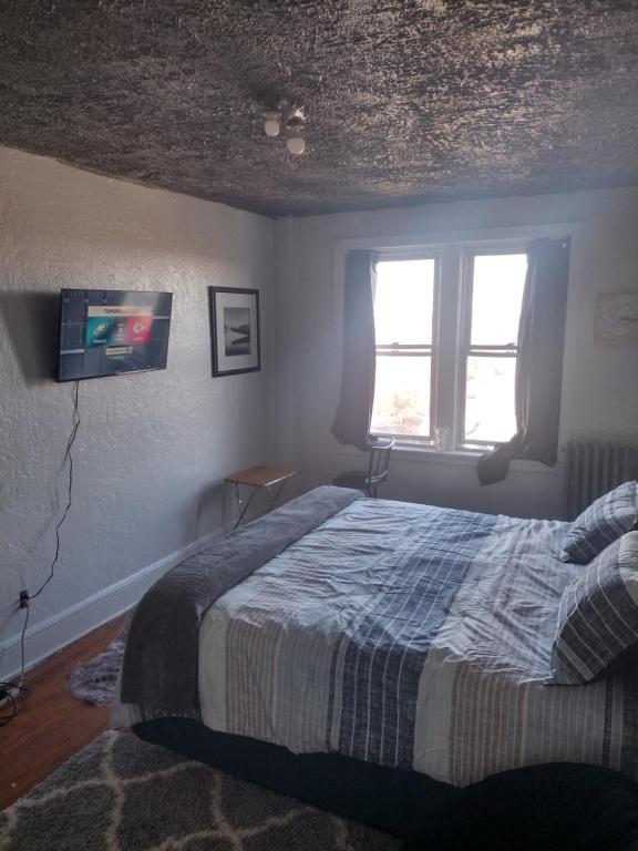 帕特森Clearviewpeace的卧室配有一张床,墙上配有电视。