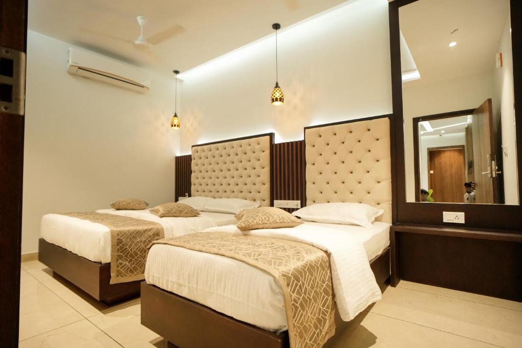 埃尔讷古勒姆Sulu Residency的一间卧室配有两张床和镜子