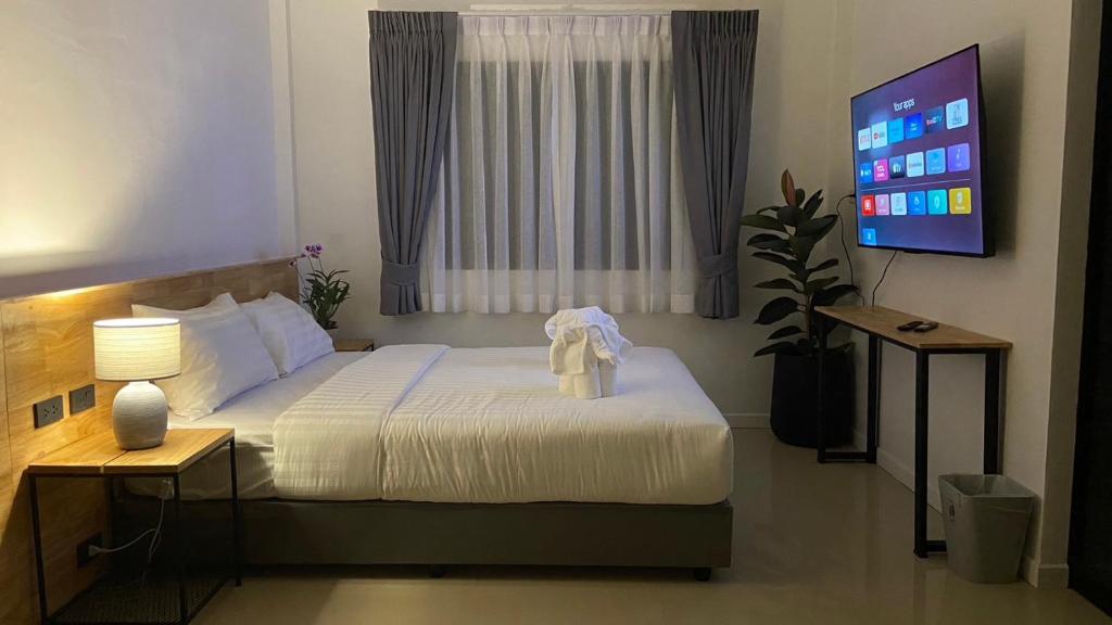 查龙B House Phuket @Chalong的一间卧室配有一张床,并在一间客房内配有电视。