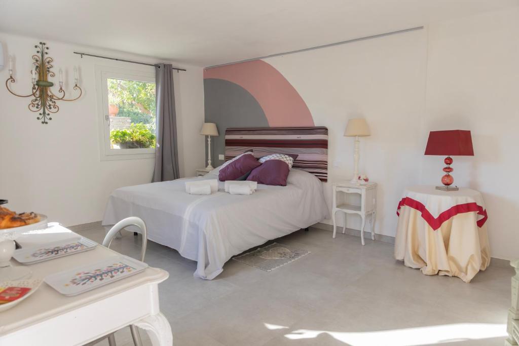 博尔迪盖拉Villa Gerani的白色卧室配有床和桌子