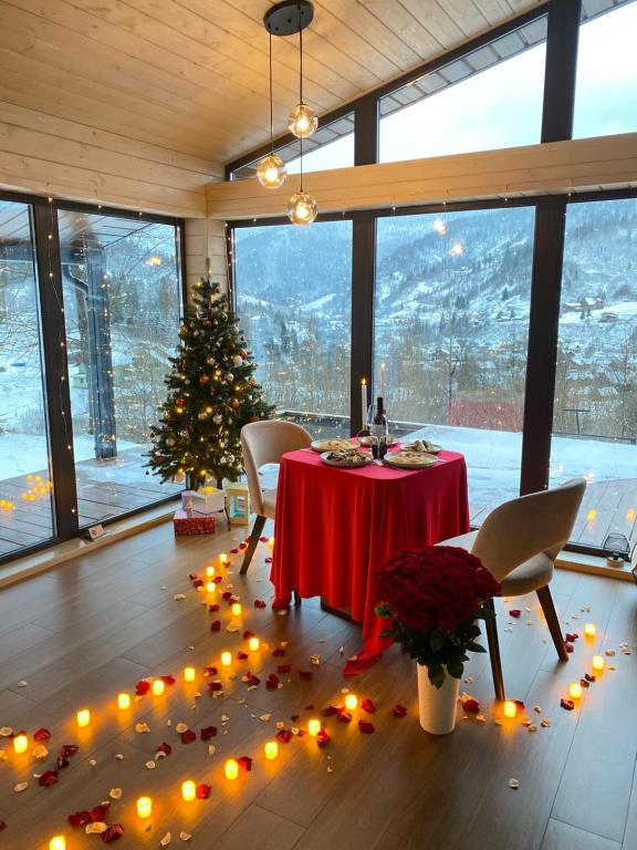 斯拉夫西克Mirest - котедж в горах із чаном-джакузі的一间设有桌子的房间,配有圣诞树和灯