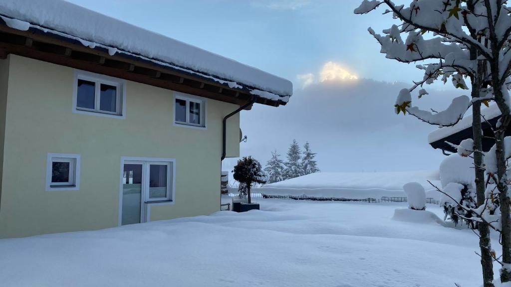 豪斯地区圣雅各布Ferienhaus Kapeller的雪中的房子,背景是山