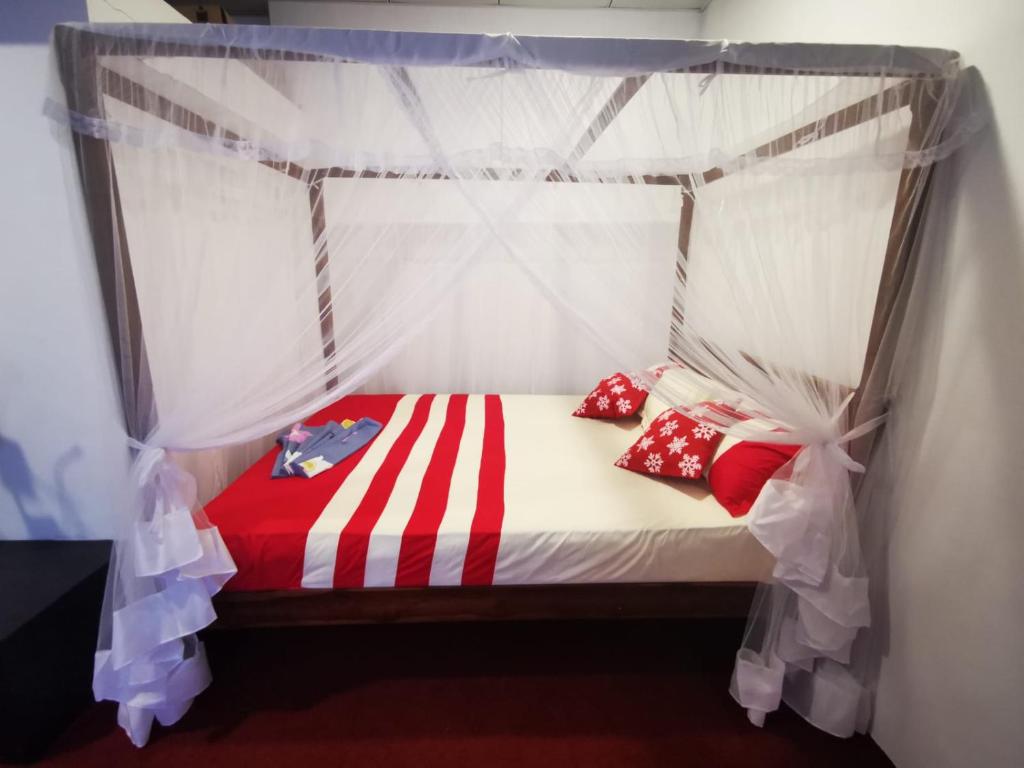 高尔Villa Sea View的一张带红色和白色枕头的华盖床