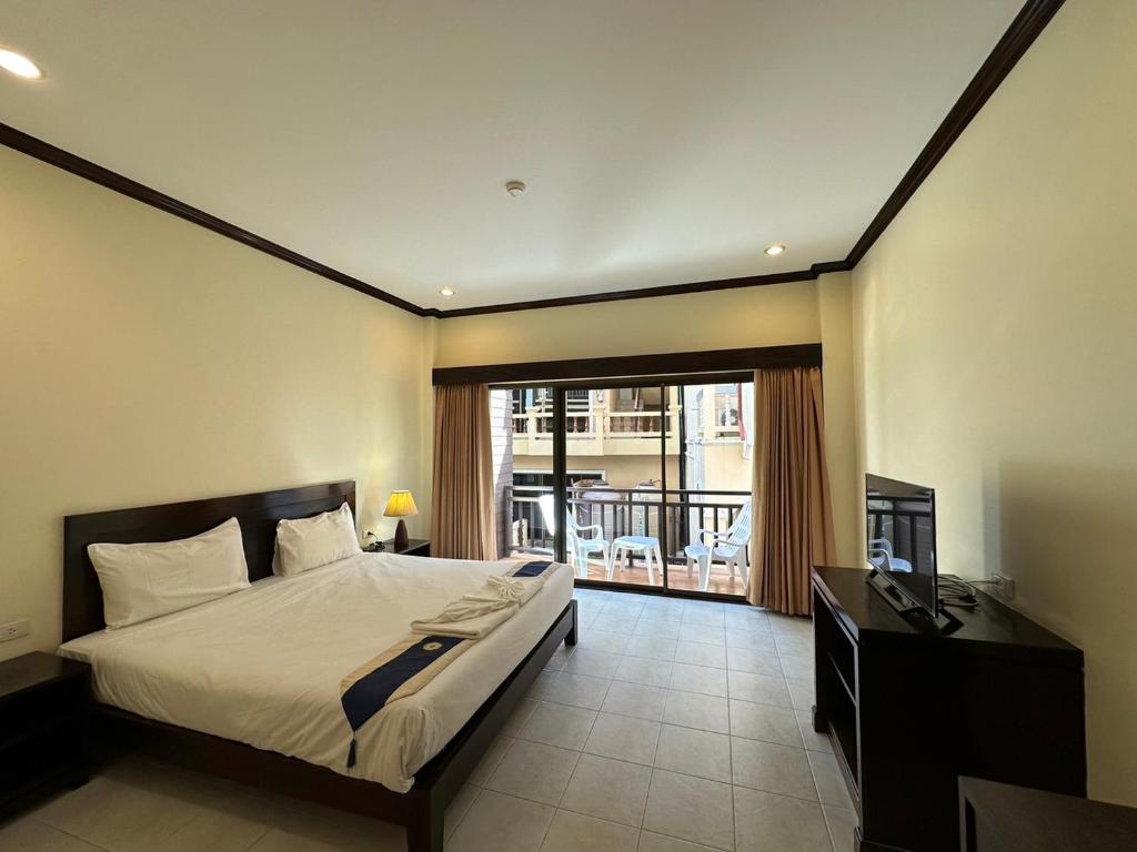 芭东海滩Baan Kingkeaw Thamdee Patong的一间卧室配有一张床、一张书桌和一个窗户。
