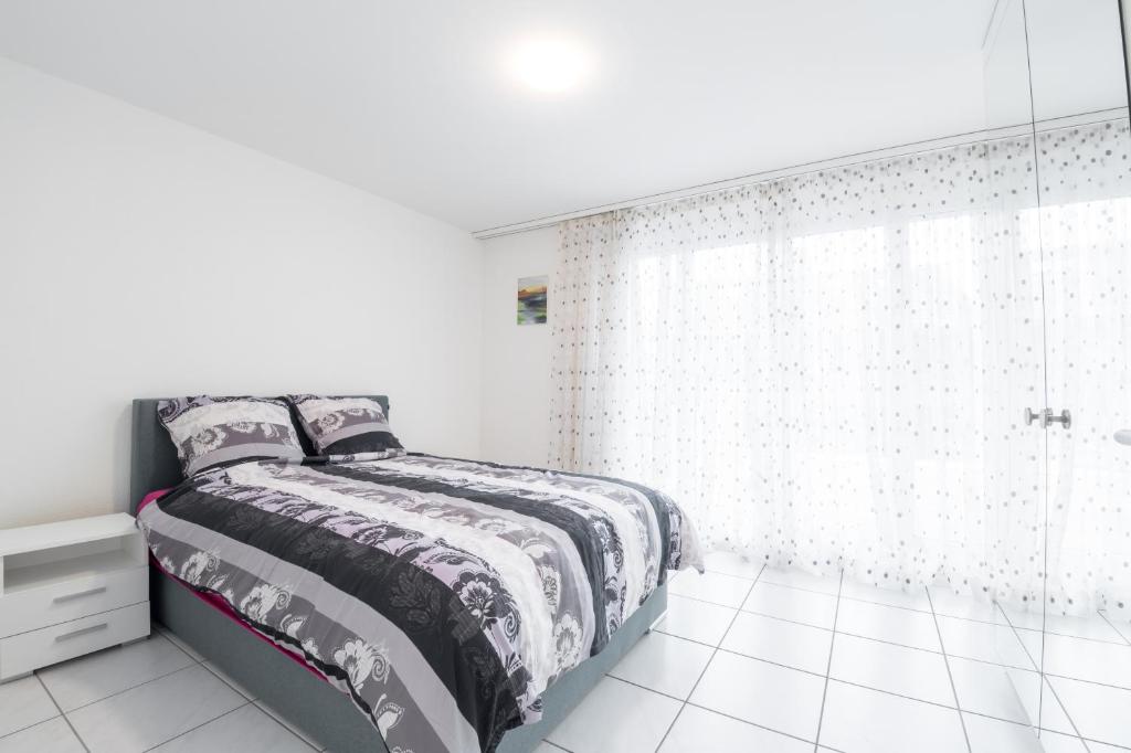 Würenlos3.5 Room Apartment的白色卧室配有一张床和淋浴
