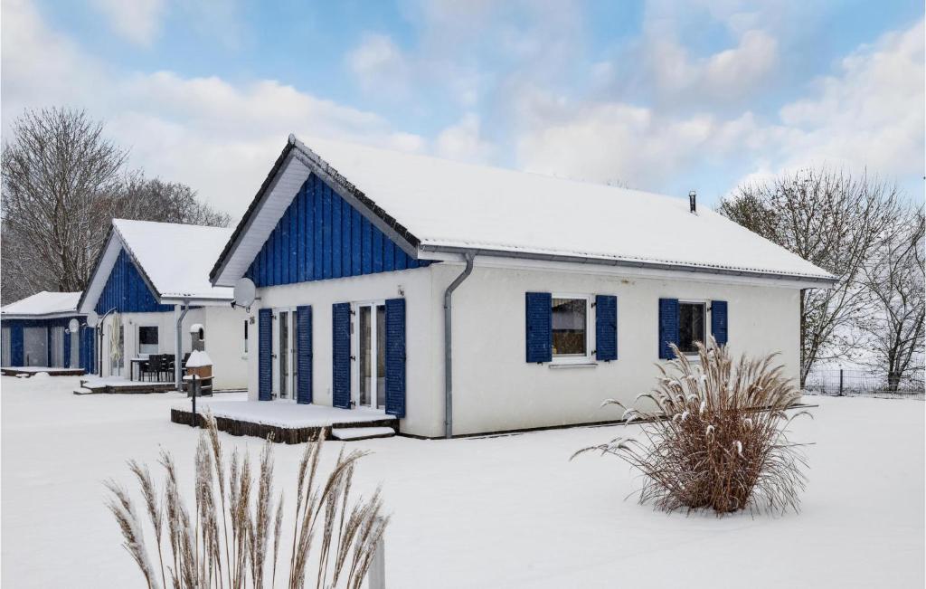 阿尔特费尔阿尔特费尔/吕根岛87号度假屋 - 带桑拿浴室的雪中白色和蓝色的房子