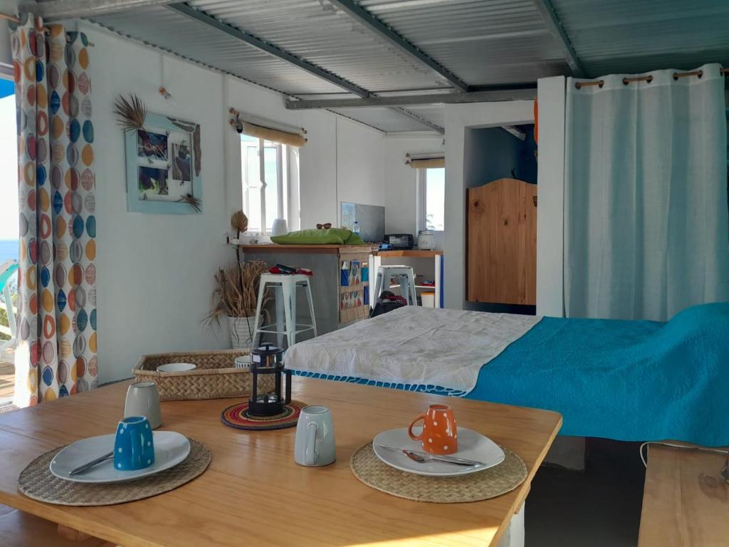 Rodrigues IslandBlue View Terrace的一间卧室配有床和一张桌子,上面有盘子