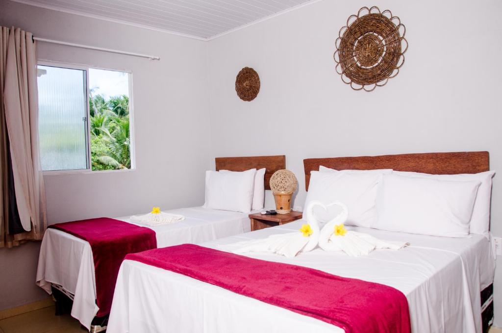圣米格尔-杜斯米拉格里斯Pousada Chalés do Toque的一间卧室配有两张红色和白色床单