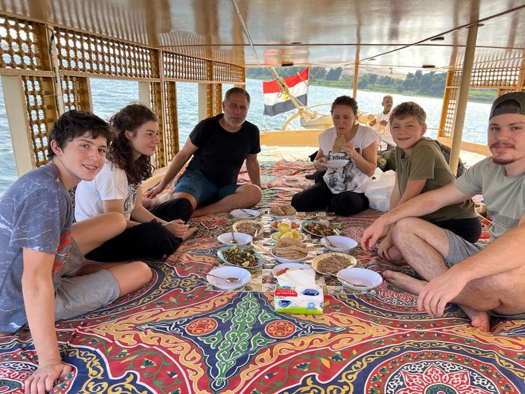 阿斯旺Nile Felucca Adventure的一群坐在船上吃食物的人
