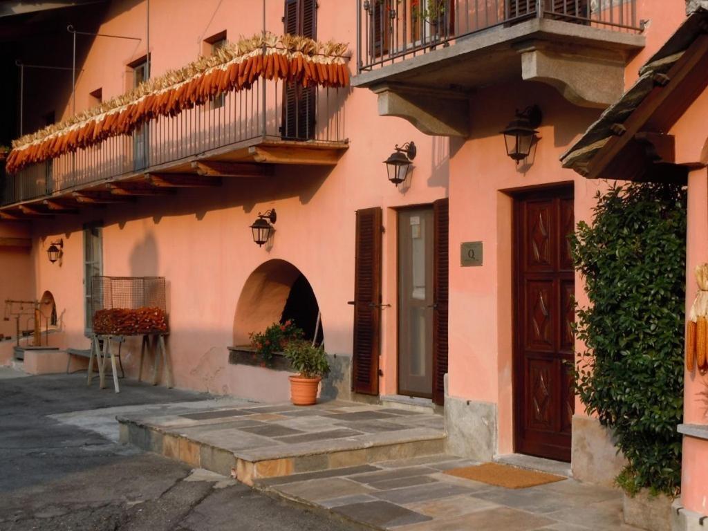 SanfrontB&B Il Mulino的粉红色的建筑,设有门和阳台