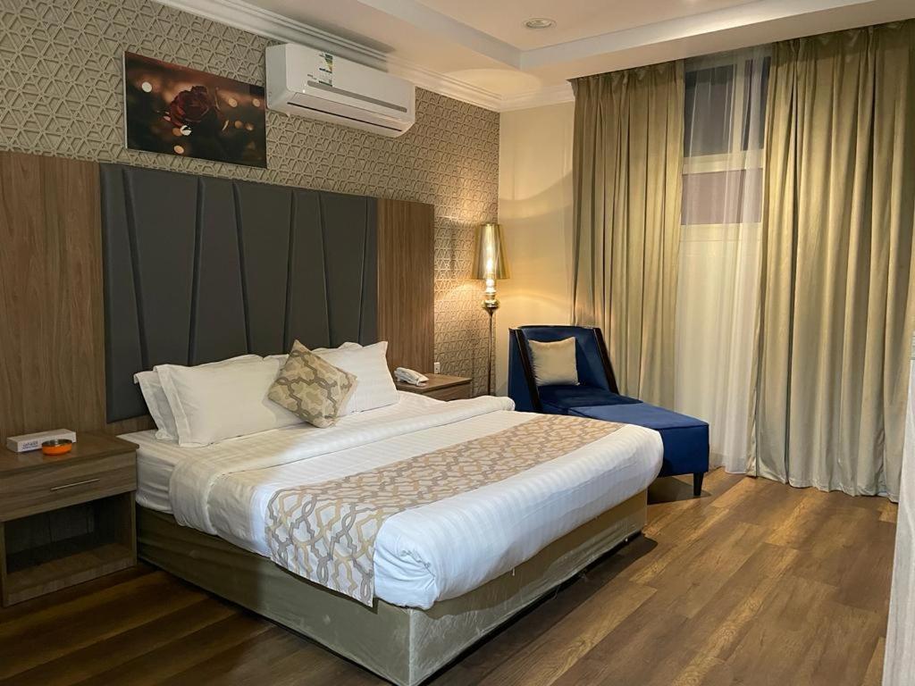 哈伊勒سكون سويت للشقق الفندقية的酒店客房,配有一张床和一张蓝色椅子