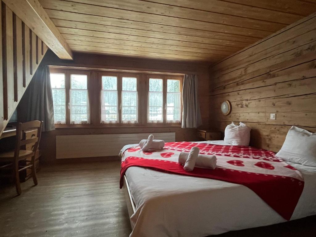 威尔斯伊格里塞L'Auberge de L'Ours的木制客房内的一间卧室配有一张大床